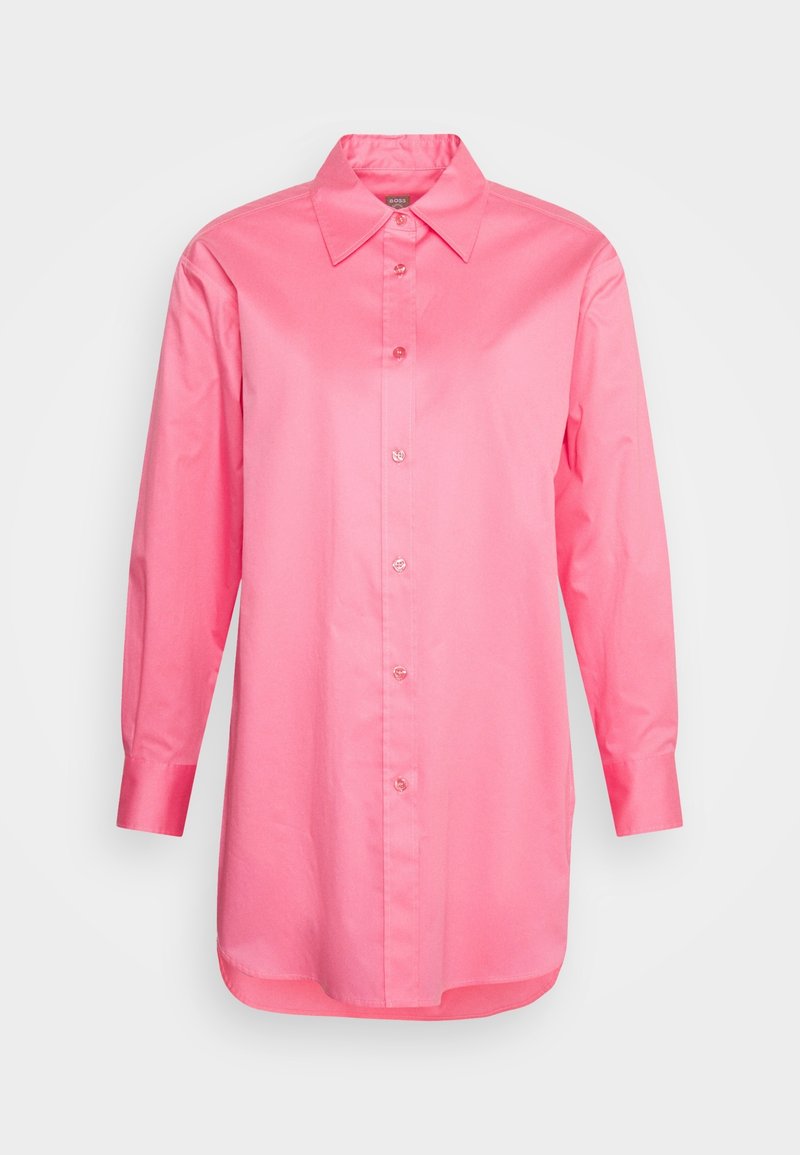 Chemise rose à manches longues avec boutons, col pointu et manches à poignets, présentée sur fond blanc.