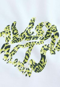 Bílá látka se zeleným potiskem leopardího vzoru, která tvoří text "Londýn" ve fluidním, vlnitém stylu s hladkým povrchem.