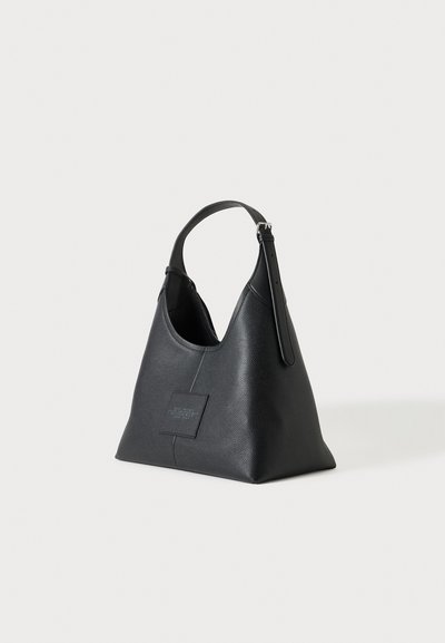 Sac à main en cuir noir avec une forme triangulaire, une sangle réglable unique et un petit patch carré embossé à l'avant.