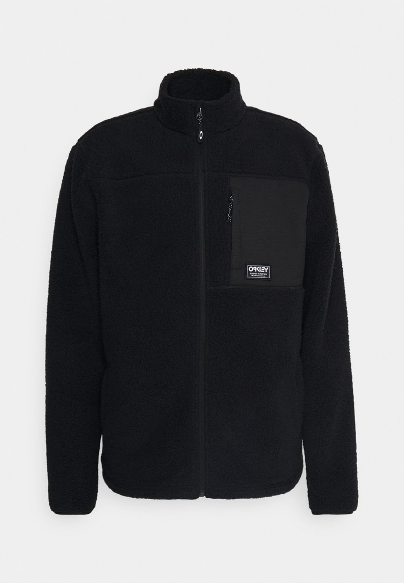 Chaqueta de forro polar negra con cuello alto, cremallera frontal y bolsillo en el pecho izquierdo. Presenta una tela texturizada y un parche con el logo en el bolsillo.