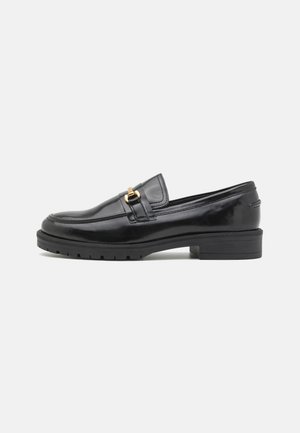 Mocassins en cuir verni noir avec un bout arrondi, accent en métal doré, semelle en caoutchouc texturé et petit talon bloc.