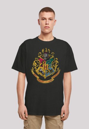 Black cotton t-shirt featuring a colorful Hogwarts crest design with a gold border, displaying various mythical creatures and text.