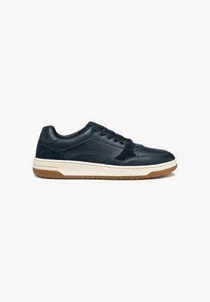 Navy leather sneaker with a smooth finish, textured accents, and perforated detailing; features a cream midsole and gum rubber outsole.