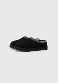 Black suede clogs with a textured black rubber sole, featuring a contrasting braided trim around the opening and a rounded toe design.