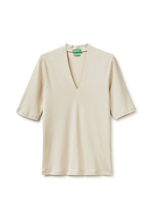 Camicia beige a maniche corte con colletto a V profondo, distesa su uno sfondo bianco.