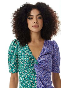Dress with a green and pink abstract pattern on one side and a blue and peach design on the other. Features a deep V-neck and gathered detail.
