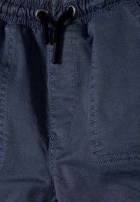 Marinblå shorts tillverkade av lättviktsmaterial, med en elastisk midja och svarta dragsko, samt två sidofickor med subtil sömnad.