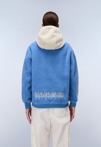Blue fleece jacket with a cream hood, featuring a textured surface and the "Napapijri" logo in light blue on the back.