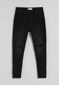 Svarta smala jeans med slitna knäveck, femfickorsdesign, dragkedja och bältesömmar. Tillverkade av denim med en mjuk textur.