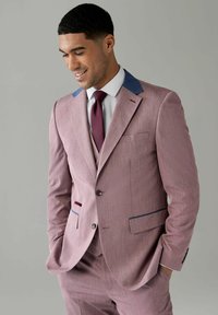 Helles rosa Anzug mit blauen Kragenakzenten, feiner Textur, zwei-Knopf-Verschluss und passenden Hosen. Getragen mit einem weißen Hemd und einer burgunderroten Krawatte.