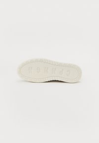 Gummisåle i off-white med et teksturert mønster, med en hevet logo og små sykkelmotiver langs kantene.