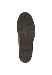 Semelle extérieure en caoutchouc brun avec des sculptures profondes ; présente une surface texturée et un design contouré pour la traction et la stabilité.