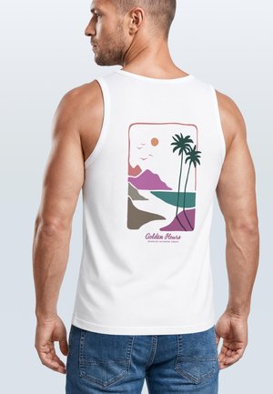 Mann trägt ein weißes Tanktop mit einer bunten Strand-Szene und dem Text „Golden Hours Neverless Saltwater Therapy“ auf dem Rücken.