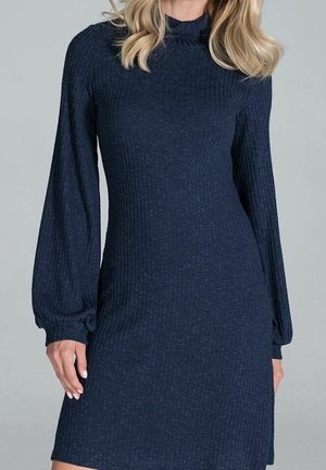 Navy blue ribbed knit dress with long puffed sleeves and a high neckline, worn by a person with blonde hair.