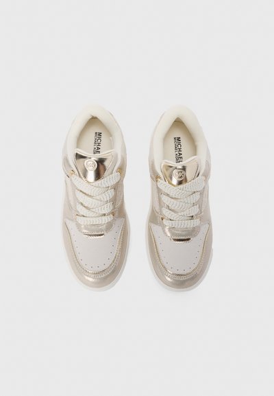 Des baskets arborant un schéma de couleurs doré métallisé et crème, une tige en cuir lisse, des lacets texturés et un accent logo rond sur la languette.