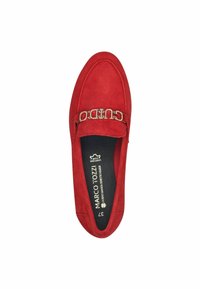 Červená semišová nazouvací bota se zaoblenou špičkou a zlatým řetízkem jako akcentem. Měkká textura a polstrovaná vnitřní sole s brandingem uvnitř.