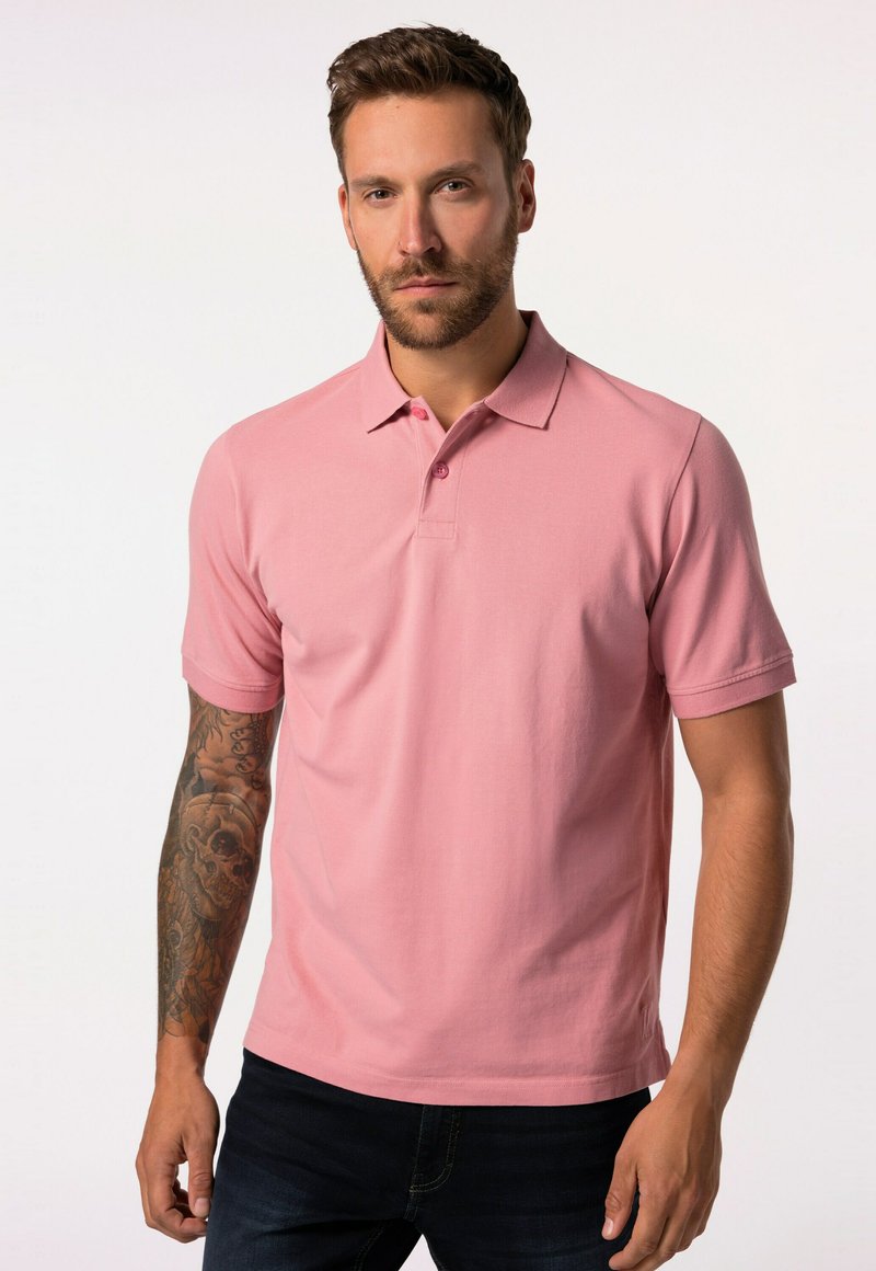 Kortärmad rosa polo skjorta med klassisk krage, två knappslå och strukturerad tyg. Bärs med mörkblå jeans.