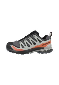 Scarpa sportiva nera e grigia con un accento arancione, dotata di una tomaia in mesh, suola in gomma e un sistema di lacci sicuro per la stabilità.