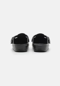 Sandale negre tip slip-on, cu un finisaj neted și lucios, având două curele ajustabile și un design al tălpii conturat pentru confort.