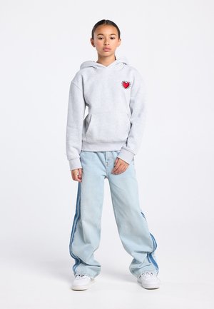 Gray hoodie with a heart graphic on the chest, paired with light blue wide-leg jeans featuring side stripes and white sneakers.