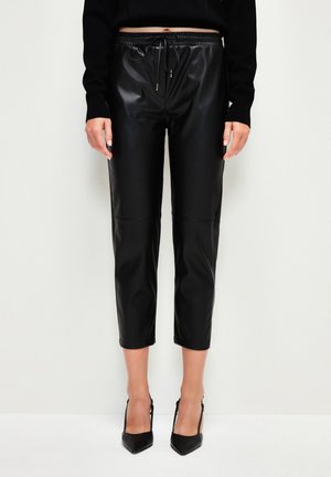 Zwarte leren look, cropped broeken met een elastische tailleband en trekkoord. Gladde textuur, met een naaddetail aan de voorkant.