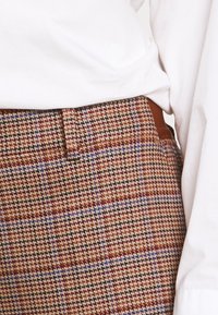Wollen broek in een blend met een ruitpatroon in bruin, crème en paars, met een rechte snit en een bruine tailleband.