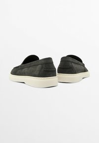 Schlüpfschuhe aus dunkelgrauem Wildleder mit einer weißen Gummisohle, die über minimalistische Nähte und ein abgerundetes Zehendesign verfügt.