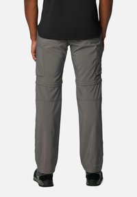 Lightweight, gray zip-off pants with a cargo pocket, elastic waistband, and reinforced seams, paired with dark footwear.