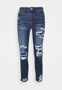 Mörkblå denimjeans med slitna detaljer, som har flera hål och fransade kanter. Snäv design med en klassisk femficksmodell.