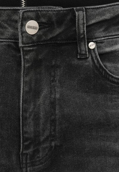 Čierne džínsy z denimu s tradičným dizajnom piatich vreciek, uzatváranie na kovový gombík a textúrovaný povrch s jemným vyblednutím a detailmi prešívania.