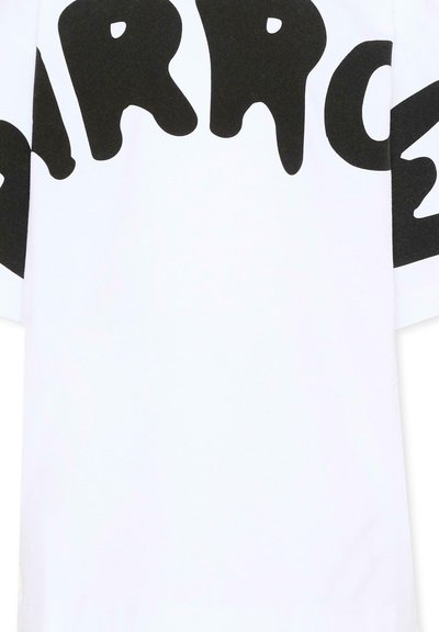 T-shirt blanc avec un large texte noir en style goutte d'eau épelé "MARC" traversant la partie supérieure de la poitrine et les épaules.