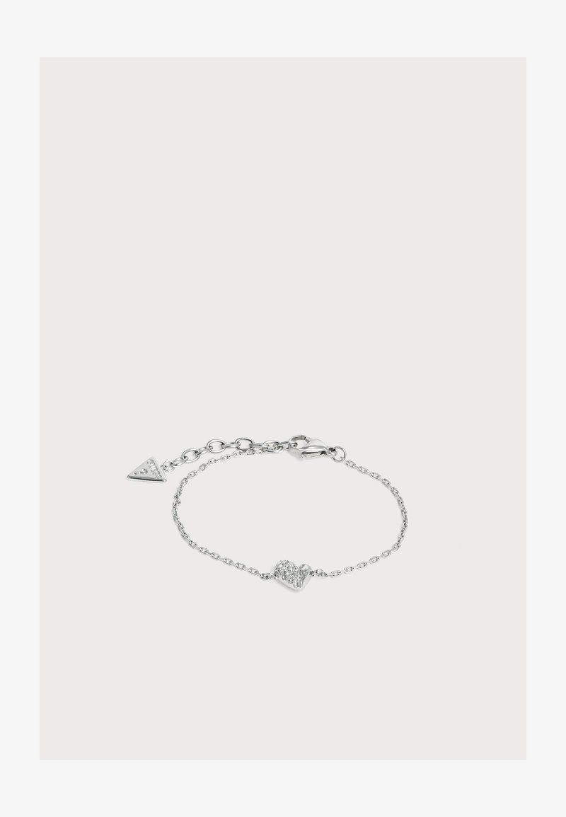Bracelet délicat en chaîne argentée avec un petit charm en forme de cœur orné de cristaux clairs et une fermeture ajustable avec une étiquette triangulaire.
