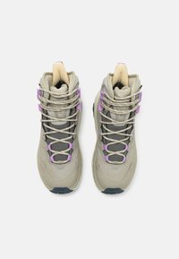 Korkeat lenkkarit vaaleanbeigeinä ja tummanharmaana, joissa on violetteja yksityiskohtia, verkkokangasta, ja vaaleanbeigejä nauhoja, sekä teksturoitu kieli ja pohja.