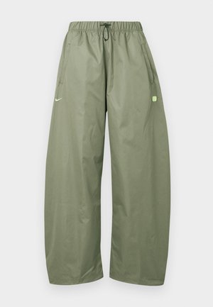 Φαρδιά λαδί παντελόνια με ελαστική μέση, κορδόνι, πλευρικές τσέπες και μικρό ανοιχτό πράσινο λογότυπο στο αριστερό μηρό.