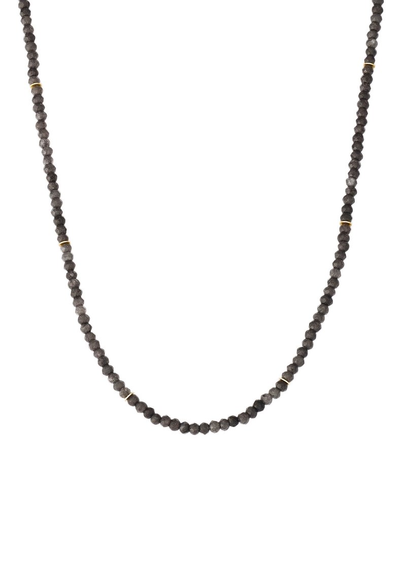 Juodas karoliukas su facetuotais brangakmeniais ir auksiniais akcentais, turintis lygų, vienodą virvės dizainą.