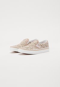 Slip-on sneakers med blomstermønster i rosa og hvitt, med hvit gummisåle og lett polstring. Pyntet med en beige kant.
