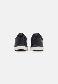 Marina sneakers med en slät läderfinish, slip-on-design, svarta accenter, kontrasterande vit sula och dragflik bak.