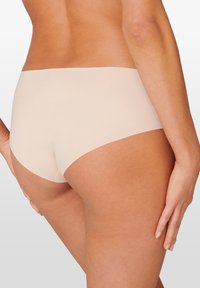 Naadloze beige hipster slips met een gladde textuur en een laag uitgesneden ontwerp, bieden volledige bedekking met minimale lijnen.