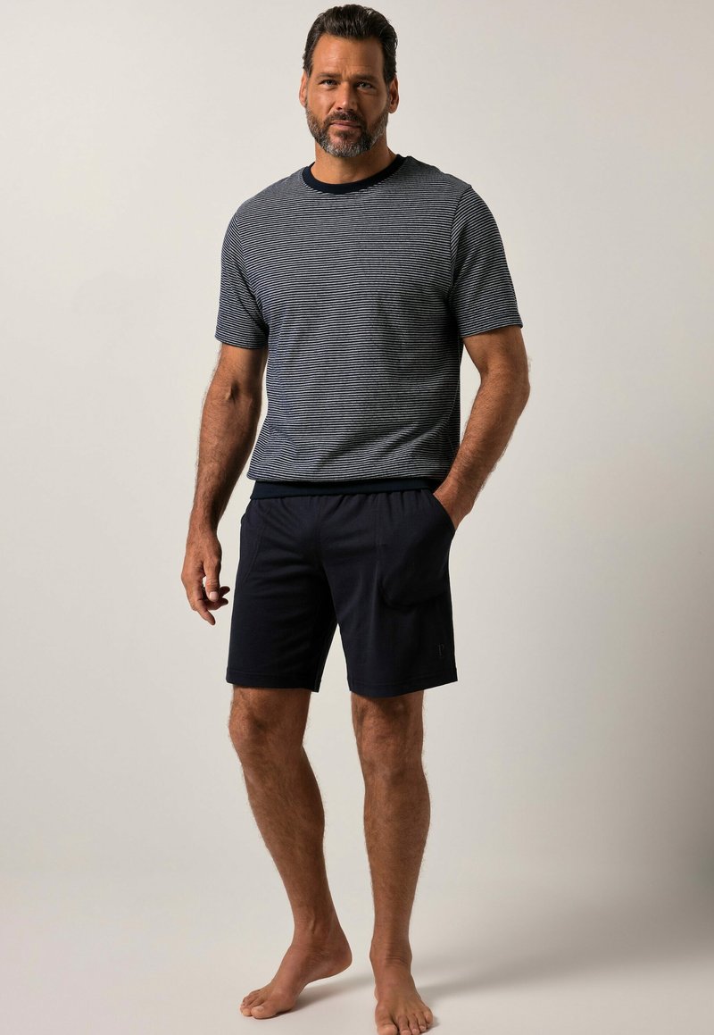 Šedé a námořnické pruhované tričko s krátkým rukávem a žebrovaným límcem, v kombinaci s tmavě námořnickými šortkami; obojí vyrobeno z měkkého a prodyšného materiálu.