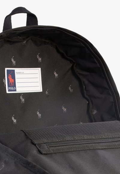 Interiér čierneho batohu s opakuj�úcim sa vzorom loga pony, sekciou na označenie a zipsovým vreckom na bezpečné ukladanie.