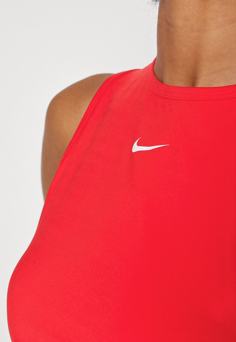 Débardeur de sport rouge avec une texture lisse, arborant un logo Nike blanc sur le côté gauche et un design sans manches classique.