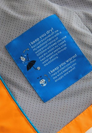 Etichetă din material textil albastru cu instrucțiuni de îngrijire; conține text și ilustrații pe un fundal gri deschis, punctat, cu accente portocalii pe margine.