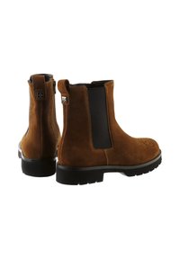 Brune suede ankelstøvler med elastiske sidepaneler, perforerede tådetaljer og slidstærke sorte gummisåler. Lynlåslukning bagpå.