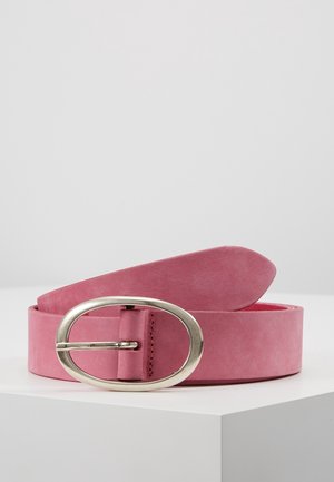 Pink ruskindsbælte med oval sølvfarvet metalspænde, vist sammenrullet på en hvid overflade mod en ensfarvet lys grå baggrund.