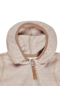 Light pink fleece hoodie with a rounded hood, tan trim, and visible stitching. Features a metallic zipper with a leather pull tab.