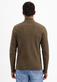 Olijfgroene geribbelde trui met een hoge kraag, lange mouwen en een aansluitende zoom, gemaakt van textuurgebreide stof.
