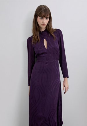 Vestido morado de manga larga con escote en forma de lágrima, patrón de ondas texturizadas y silueta fluida, confeccionado en una tela suave.