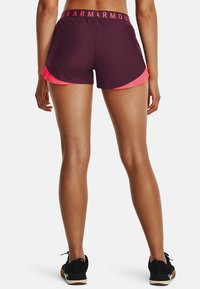 Fialové sportovní šortky s růžovým bočním panelem, vybavené širokým pasem s logem značky. Hladká tkanina a přiléhavý střih.