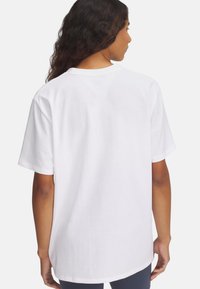 Camiseta de algodón blanca de ajuste relajado, con cuello redondo y mangas cortas, que presenta una textura suave y sin patrones ni acentos visibles.