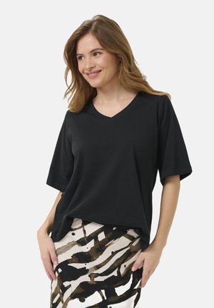 Black, short-sleeved V-neck T-shirt in a relaxed fit, paired with a patterned skirt featuring bold abstract brown and cream stripes.